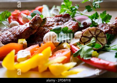 Club Beef Steak mit Pfeffersauce und gegrilltem Gemüse auf dem Schneidebrett auf dunklem Holzhintergrund. Hochwertiges Foto Stockfoto