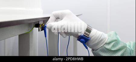 Erdungsarmband an der Hand mit ESD-Tuch für Reinräume. Antistatisches ESD-Armband oder Erdungsarmband ist ein antistatisches Gerät, das zur sicheren Gro verwendet wird Stockfoto