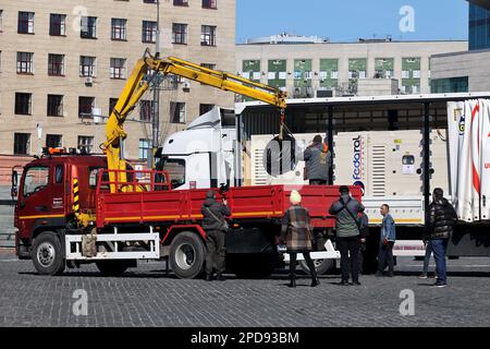 Nicht exklusiv: CHARKIV, UKRAINE - 14. MÄRZ 2023 - Menschen werden beim Entladen von 17 Generatoren, die in der Türkei mit dem hergestellt wurden, fotografiert Stockfoto