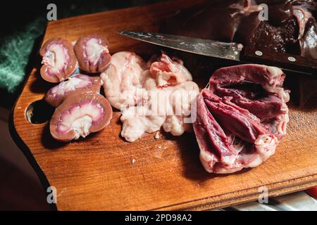 Rohe Scheiben von Nieren, Herz und Hoden eines Lammes, bereit zum Kochen. Eingeweide, Eingeweide und Darmpräparation. Stockfoto