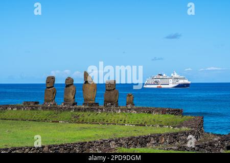 Osterinsel, Chile - 5. März 2023: Moai-Statuen auf Ahu Vai Ure mit einem Kreuzfahrtschiff im Hintergrund im Tahai-Komplex auf der Osterinsel, Chile. Stockfoto