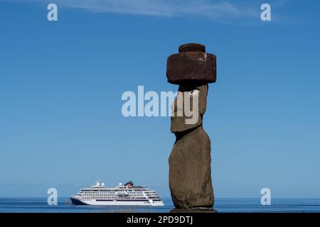 Osterinsel, Chile - 6. März 2023: Der Moai mit Kopfbedeckung und Blick auf Ahu Ko Te Riku mit einem Kreuzfahrtschiff im Hintergrund auf der Osterinsel Stockfoto