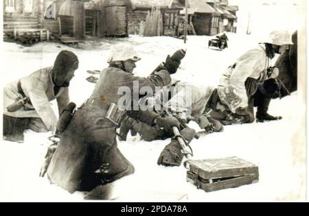 B&W-Foto des 2. Weltkriegs Deutsche Soldaten feuern in den Wintermonaten 1941/42 einen Mörtel auf die russische Front ab . Diese Soldaten sind schlecht gekleidet mit einer Vielzahl von Winterkleidung Stockfoto