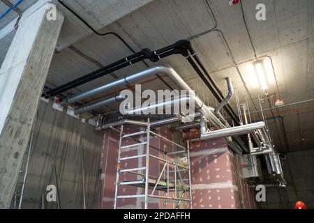 Heizungs- und Kühlsystem des Gebäudes. Neue Rohrinstallation, unter der Decke in der Nähe der Gipskartonwand montiert. Stockfoto