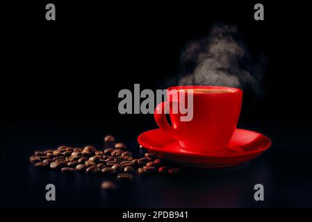 Rote Tasse heißen schwarzen Kaffees mit Dampf und Kaffeebohnen auf dunklem Hintergrund. Unauffällig. Speicherplatz kopieren Stockfoto