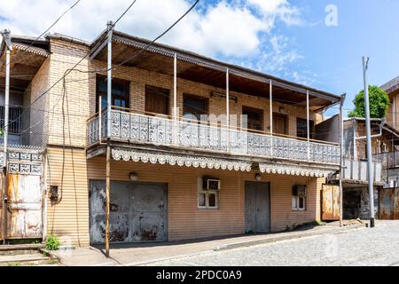 Traditionelles zweistöckiges Wohnhaus in Kutaisi mit gestrichenem, offenen, dekorativen Balkon. Stockfoto