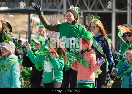 St. Patrick's Day Parade: Grün gekleidete Kinder marschieren entlang der Parade und winken. Halifax, Kanada, März 2023 Stockfoto