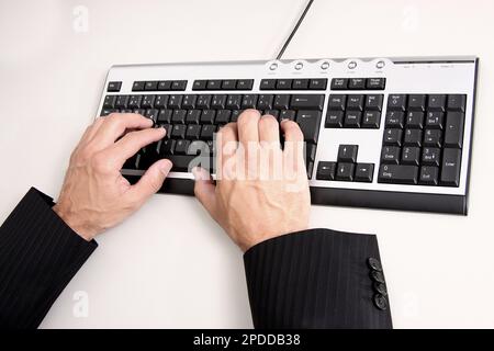 Männerhände tippen auf der Computertastatur Stockfoto