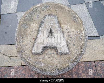 Brief A aus Stein. Ein in Beton geschnitzter Buchstabe A. Alphafit aus Beton gegossen. Das Konzept des Buchstaben A. im Park. Zuerst Stockfoto