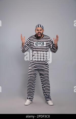 Emotionaler Gefangener in Spezialuniform auf grauem Hintergrund Stockfoto