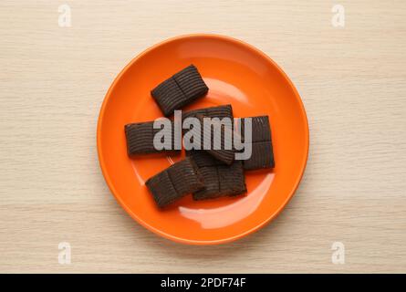 Orangefarbene Platte mit köstlichem und gesundem Hämatogen auf Holztisch, Draufsicht Stockfoto