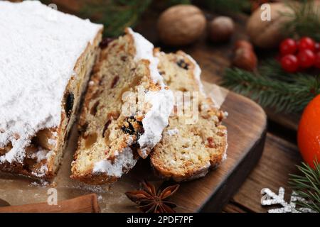 Traditionelles Weihnachtsstollen mit Puderzucker auf Holztisch, Nahaufnahme Stockfoto