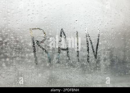 Das Wort "Regen" steht auf nebligen Fenstern, Nahaufnahme Stockfoto