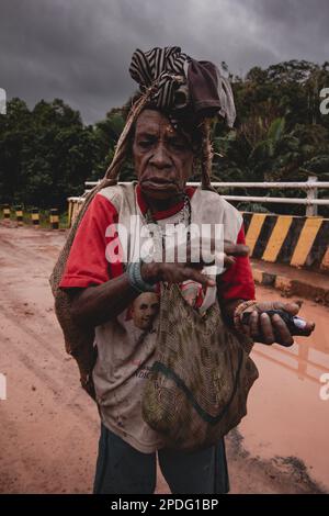 Eine ältere Frau mit einer Tasche spaziert am 2017. September im Inneren von Papua bei bewölktem Himmel in Indonesien Stockfoto