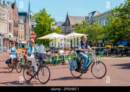 Leeuwarden Niederlande 2018. Mai, heller Sommertag an den Kanälen der Altstadt mit Menschen auf Fahrrädern in der Stadt. Stockfoto