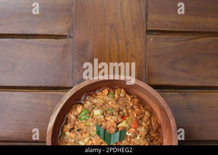 Ein Rujak-Bebek oder zerstoßenes Obst aus rohem Obst, das in Mörtel und Stößel zermahlen und mit Garnelpaste, Chili und braunem Zucker hinzugefügt wird Stockfoto