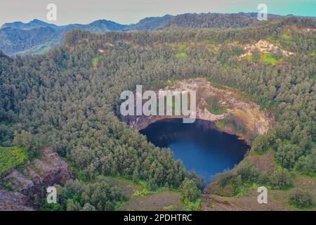 Panoramablick auf den kleineren, tiefblauen Kratersee des Vulkans Mount Kelimutu in Ende auf Flores. Stockfoto