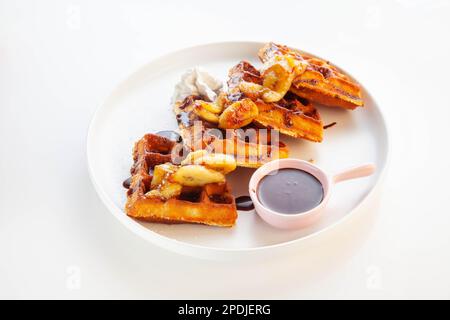 Schokoladen-Bananen-Waffel serviert mit Ahornsirup. Stockfoto