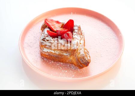 erdbeergebäck auf einem rosafarbenen Teller. Stockfoto