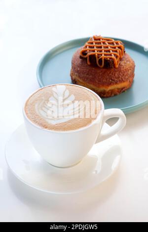 Eine Tasse Cappuccino-Kaffee mit Schokoladen-Brownie-Donut. Stockfoto