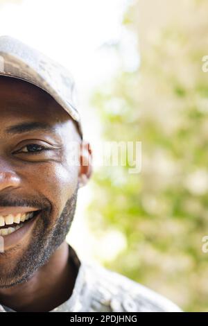 Porträt eines glücklichen afroamerikanischen Soldaten, der in die Kamera schaut und lächelt, mit Kopierraum Stockfoto