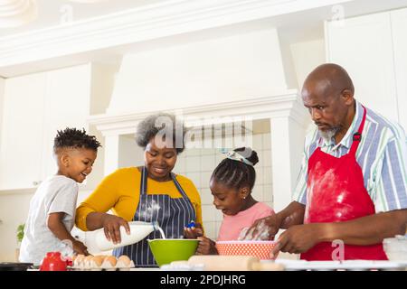 Glückliche afroamerikanische Großeltern und Enkel, die zusammen in der Küche backen Stockfoto