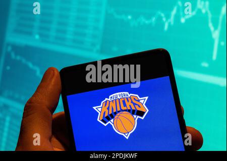 China. 15. Februar 2023. In dieser Fotoabbildung ist das New York Knicks-Logo des amerikanischen Profi-Basketball-NBA-Teams auf einem Smartphone zu sehen, das im Hintergrund mit einer Grafik des Börsenindex versehen ist. (Kreditbild: © Budrul Chukrut/SOPA Images via ZUMA Press Wire) NUR REDAKTIONELLE VERWENDUNG! Nicht für den kommerziellen GEBRAUCH! Stockfoto