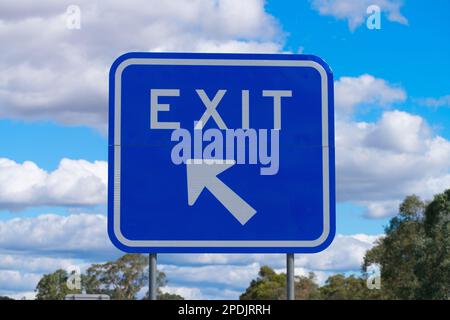 Australisches Ausfahrtsschild auf der Autobahn mit Pfeil und Richtung auf blauem metallischem Hintergrund, Victoria, Australien. Stockfoto