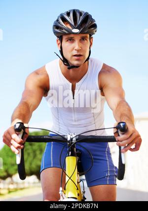 Genießen Sie die Landschaft beim Training. Beschnittene Ansicht eines Radfahrers, der entlang einer Meeresstraße radelt. Stockfoto