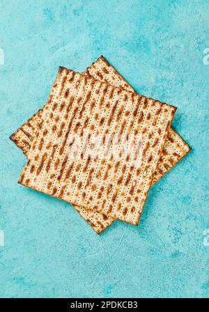 Pesach-Festungskonzept - jüdischer Feiertag Pesach. Matzah-Quadrate übereinander gestapelt auf blauem Hintergrund Stockfoto