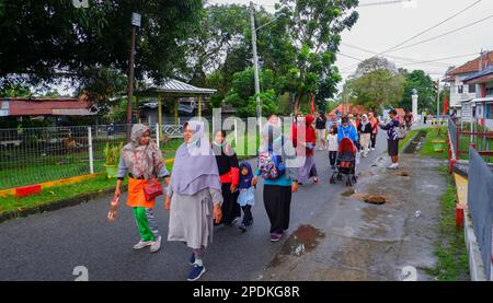 Frauen mittleren Alters gehen gemütlich mit ihren Familien auf den Straßen von Muntok City Stockfoto