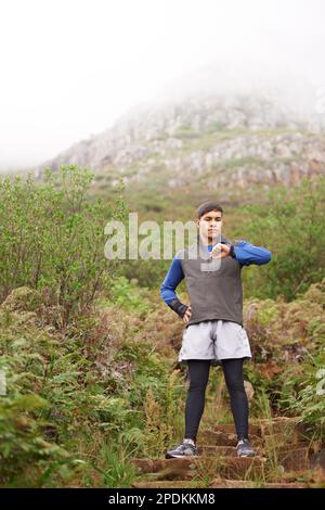 Meine Zeit hat sich verbessert. Ein Mann schaut auf seine Uhr, während er auf einem Wanderweg steht. Stockfoto