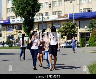 Junge usbekische Frauen, die im Stadtzentrum von Taschkent, Usbekistan, spazieren gehen und sich unterhalten. Stockfoto