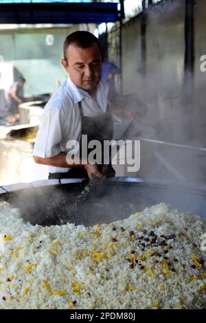 Riesige Kessel überlaufen mit Usbekistans beliebtestem Reisgericht im zentralasiatischen Plov Center in Taschkent, Usbekistan. Stockfoto