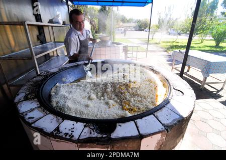 Riesige Kessel überlaufen mit Usbekistans beliebtestem Reisgericht im zentralasiatischen Plov Center in Taschkent, Usbekistan. Stockfoto