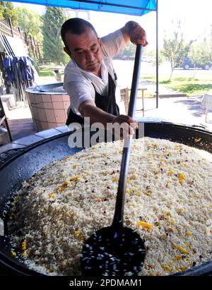 Riesige Kessel überlaufen mit Usbekistans beliebtestem Reisgericht im zentralasiatischen Plov Center in Taschkent, Usbekistan. Stockfoto