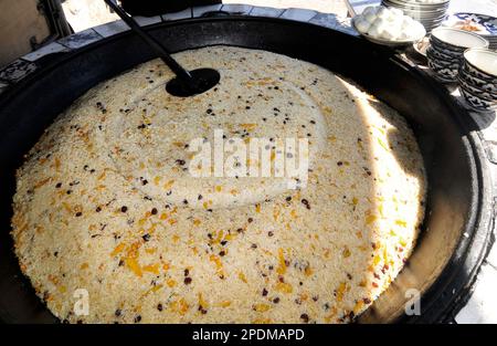 Riesige Kessel überlaufen mit Usbekistans beliebtestem Reisgericht im zentralasiatischen Plov Center in Taschkent, Usbekistan. Stockfoto