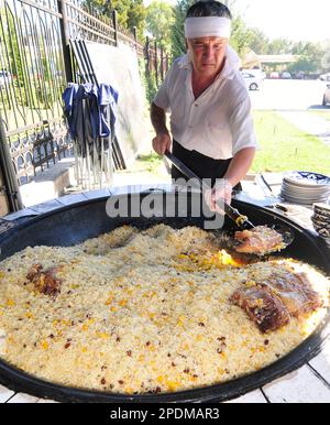 Riesige Kessel überlaufen mit Usbekistans beliebtestem Reisgericht im zentralasiatischen Plov Center in Taschkent, Usbekistan. Stockfoto