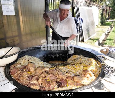 Riesige Kessel überlaufen mit Usbekistans beliebtestem Reisgericht im zentralasiatischen Plov Center in Taschkent, Usbekistan. Stockfoto