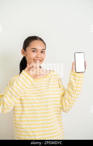 Der junge Aisan grillt auf isoliertem weißem Hintergrund und sendet eine Botschaft Stockfoto