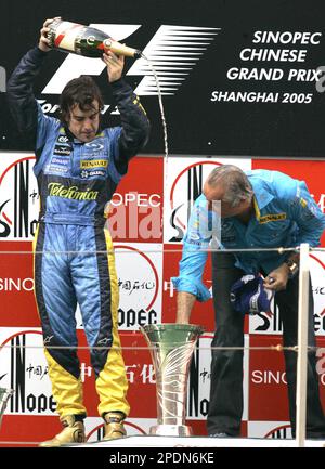 Spanish Formula One world champion Fernando Alonso, left, pours champagne to the Formula One constructors championship trophy on the podium as Renault team director Flavio Briatore looks on during the award ceremony after Alonso won the Chinese Formula One Grand Prix at Shanghai International Circuit, China, Sunday, Oct. 16, 2005. (AP Photo/Ng han Guan)