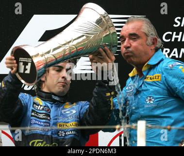 Spanish Formula One world champion Fernando Alonso, left, and Renault team director Flavio Briatore drink champagne from the Formula One constructors championship trophy on the podium after winning the Chinese Formula One Grand Prix in Shanghai, China, Sunday Oct. 16, 2005. Alonso won the season-ending Chinese Grand Prix on Sunday to clinch his Renault team's first-ever Formula One constructors' title. (AP Photo/Greg Baker)