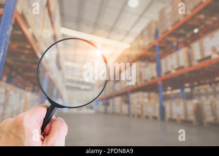 Lupe auf den Hintergrund des Lagerbestands. Produktbestand suchen Regalmanagement für Chargennummern der Fracht. Stockfoto