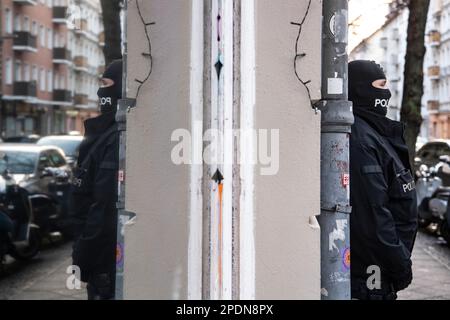 Berlin, Deutschland. 15. März 2023. Polizeibeamte sind während einer Razzia in Berlin im Dienst. Die Polizei in Berlin und Sachsen-Anhalt hat eine große Razzia gegen eine Bande mutmaßlicher Schmuggler gestartet. Mehr als 20 Wohnungen und Büros, hauptsächlich in Berlin, wurden Mittwochmorgen durchsucht, laut einem Sprecher der Bundespolizei. Fünf Männer wurden verhaftet, vier davon in Berlin und einer in Halle. Gegen insgesamt 18 Verdächtige wird ermittelt. Die Bande soll Menschen aus der Türkei und dem Irak nach Deutschland geschmuggelt haben. Kredit: Paul Zinken/dpa/Alamy Live News Stockfoto