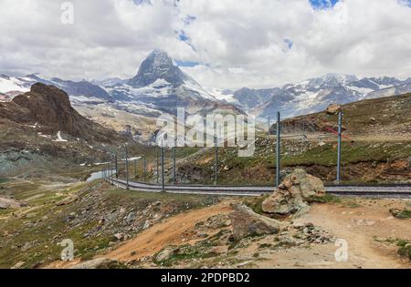 Roter Zug auf dem Hintergrund des Matterhorns in den Schweizer Alpen Stockfoto