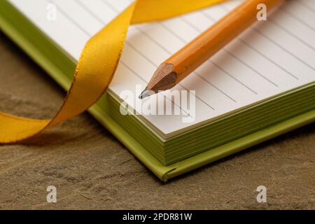 Ein liniertes Notizbuch mit einem Bleistift. Bereit, Notizen zu machen, Ideen zu skizzieren und Pläne zu schreiben. Stift und Papier bereit. Stockfoto