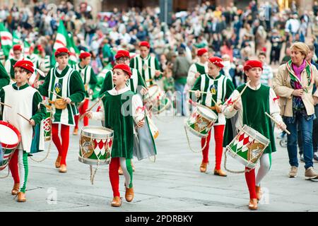 SIENA, ITALIEN - JULI 2013: Mitglieder der edlen Contrada dell'Oca tragen Fahnen mit einer gekrönten Gans auf dem Corteo Storico, einem historischen Kostümparadies Stockfoto
