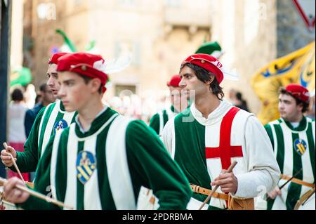 SIENA, ITALIEN - JULI 2013: Mitglieder der edlen Contrada dell'Oca tragen Fahnen mit einer gekrönten Gans auf dem Corteo Storico, einem historischen Kostümparadies Stockfoto