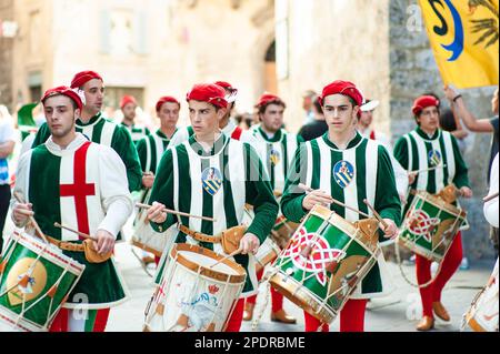 SIENA, ITALIEN - JULI 2013: Mitglieder der edlen Contrada dell'Oca tragen Fahnen mit einer gekrönten Gans auf dem Corteo Storico, einem historischen Kostümparadies Stockfoto
