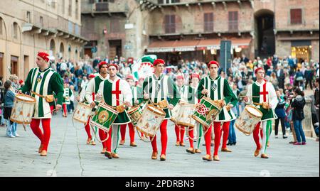 SIENA, ITALIEN - JULI 2013: Mitglieder der edlen Contrada dell'Oca tragen Fahnen mit einer gekrönten Gans auf dem Corteo Storico, einem historischen Kostümparadies Stockfoto